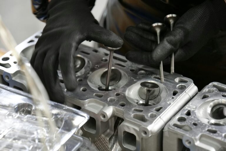 Mechanik montujący zawory w głowicy cylindrów silnika – naprawa konieczna po zignorowaniu problemu z za dużym luzem zaworowym.
